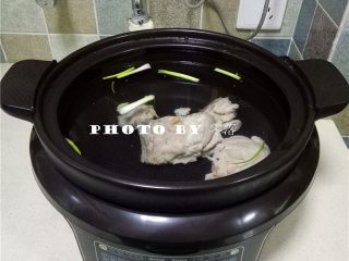 6、山药排骨汤,将排骨,剩余的姜片,葱段放入电炖锅,再加够足量的清水;