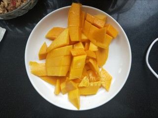 2、芒果思慕雪,两个芒果削皮，切成四半。三半切成小块，一半留着。