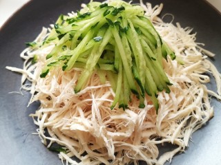 10、手撕鸡胸肉,把鸡丝放到盘子上码好，最上面放上黄瓜丝
