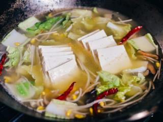 7、豆腐鱼汤,加入水、白菜、豆腐和麻油。烧开后加盐调味。