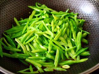 10、芸豆丝爆虾,倒入焯熟的芸豆丝，大火快速翻炒均匀。
