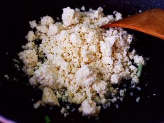 7、豆渣茼蒿虾仁小豆沫,锅中倒入豆渣，大火翻炒片刻。