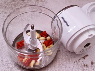 16、豆渣茼蒿虾仁小豆沫,紫皮蒜去皮，红椒洗净后切块，把红椒和蒜放入东菱无线绞肉机里。