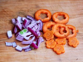 2、鹅蛋时蔬炒意面,洋葱去皮后切碎，胡萝卜用模具刻出花型，也可以直接用刀切成薄片。