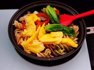 12、鹅蛋时蔬炒意面,把意面翻炒均匀后，倒入炒熟的鹅蛋和焯过水的小油菜。