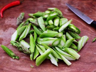 3、芦笋炒鹅蛋,然后把芦笋洗净后，斜切成滚刀状，小米辣切丁备用。