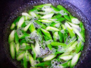 6、芦笋炒鹅蛋,锅中加入清水烧开，滴几滴油，少许盐，倒入切好的芦笋，断生变色即可捞出过冷水备用。