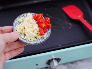 8、芦笋炒鹅蛋,另起锅加入剩下的10克花生油，倒入蒜末和小米辣。