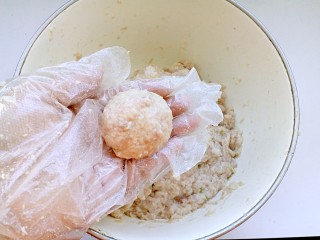 7、清蒸莲藕丸子,用手抓起40克左右拌好的莲藕猪肉馅，左右摔打团成丸子。
