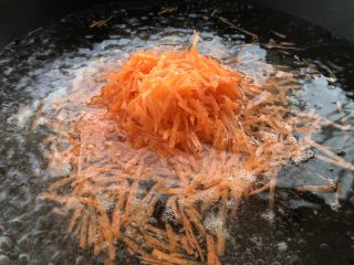 3、胡萝卜鸡蛋虾肉饼,把胡萝卜入开水中煮片刻