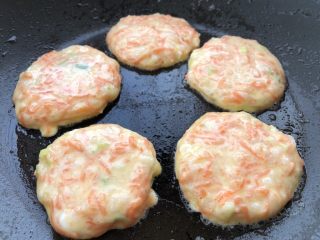 16、胡萝卜鸡蛋虾肉饼,热锅刷油，开小火，用小勺舀一勺糊糊放入锅里，并迅速摊平。