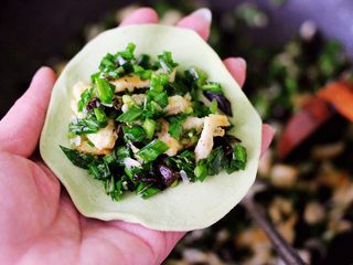 15、鹅蛋韭菜翠玉盒子,把擀好的面皮里放入适量搅拌好的馅料。