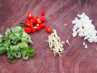 2、金牌拍蒜豉香蒸大肠,用刀把小葱和小米辣切丁,大蒜切碎,葱切丝备用。