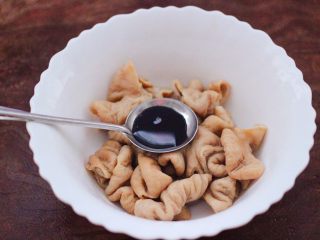 6、金牌拍蒜豉香蒸大肠,把切好的猪大肠放入一个大一点的容器,先加入生抽。