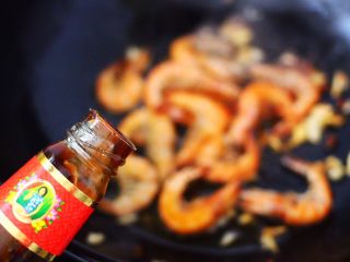 8、茼蒿海虾木耳小炒,锅中倒入蚝油调味。