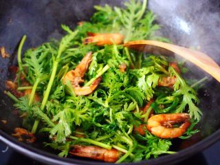 11、茼蒿海虾木耳小炒,这个时候倒入茼蒿，大火继续翻炒片刻。
