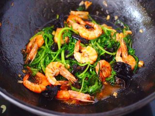 14、茼蒿海虾木耳小炒,大火继续翻炒至茼蒿断生变色的时候，即可关火咯。