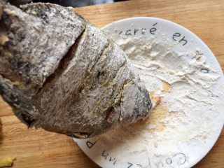 6、酸甜开胃的糖醋鱼,提起鱼抖掉多余的粉。