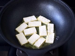 10、照烧北豆腐,锅烧热后倒入花生油烧热，放入裹好淀粉的豆腐。
