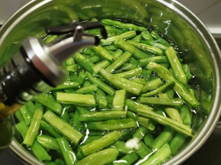 7、爆炒豆角,汤锅注入清水  烧开  放入豆角段  加入2克盐  几滴食用油