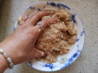 8、团团圆圆——珍珠圆子,在肉糜中,打一个鸡蛋,加入料酒、味极鲜酱油、十三香粉、盐,鸡精,香油,和山药泥一起抓拌均匀。