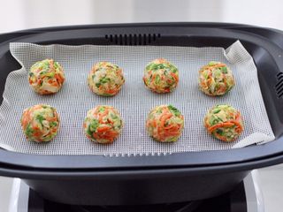 14、包菜虾皮菜团子,用手搓成大小一致的小团子，放入复式蒸屉中。