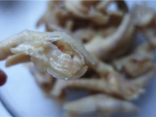 6、野山椒泡凤爪,将冲洗后的鸡爪分成2段，脚掌与腿骨分开，脚掌再分成两部分，；腿骨可以把长骨头去掉，留下顶端的关节；