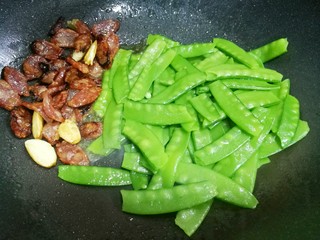 9、荷兰豆炒腊肠,加入荷兰豆迅速翻炒。