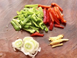 3、啤酒酱焖海鲈鱼,青椒和红椒洗净用刀切成细丝,姜切丝,葱切碎。