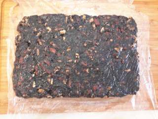 7、阿胶固元膏,然后装盘，我是把一个大的保鲜袋剪开，接触面涂点食油防粘。尽量压平整些，好让切块时不容易松散，然后封好放冰箱保鲜一天再拿出来