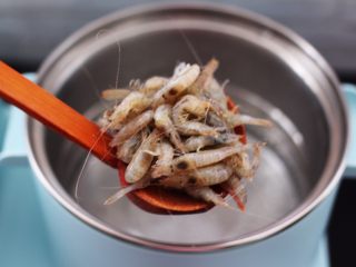 5、桃花虾爆韭菜,东菱早餐机的汤锅里，加入适量的清水烧开后，放入一勺盐后把洗净的桃花虾放入锅中。