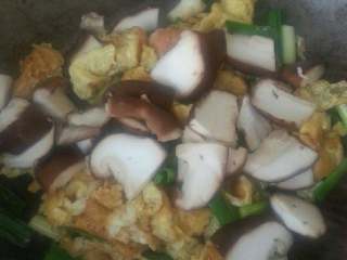 3、鸡蛋香菇汤面,依次放入蒜苗香菇老抽翻炒2分钟、