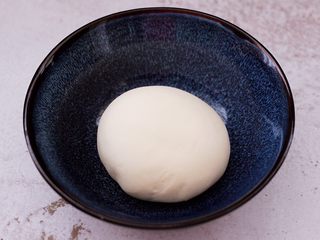 7、卤肉夹馍,和好的面团，用手揉圆后，放入碗里盖上保鲜膜进行醒发。