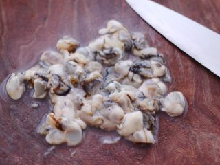 4、海蛎子西葫芦饺子,把洗净的海蛎子，用刀切成小块，我是一个海蛎子肉切了3下。
