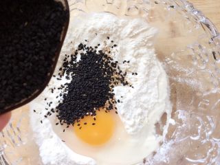 8、#咸味#～芝香南瓜烙,倒入黑芝麻，然后搅拌成面糊。