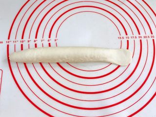 9、贝果汉堡包,将接合处捏紧，一头搓细一头压扁擀宽，尽量擀宽些。