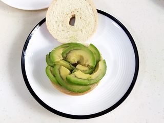 17、贝果汉堡包,放上切好的牛油果片。