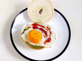 18、贝果汉堡包,放上煎好的鸡蛋，挤点番茄酱。