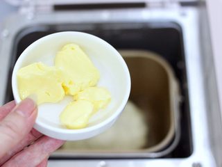 3、牛奶杏仁小餐包,揉成面团后加入软化的黄油，继续和面10分钟。