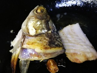 7、鱼头豆腐汤,翻面煎2分钟，煎至金黄。（鱼骨也煎一下）