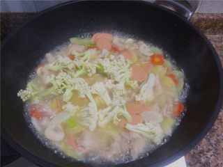 11、杂蔬滑肉,放入花菜煮约1分钟。