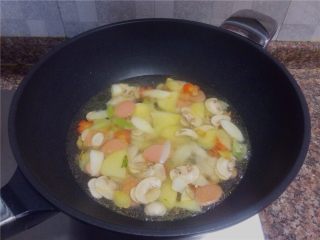 9、杂蔬滑肉,倒入两大碗清水煮开。