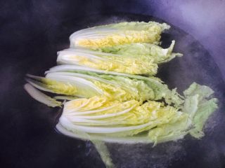 4、上汤娃娃菜,娃娃菜一切4,锅里放水,水里放少许盐和两滴油,水开后放入娃娃菜,焯烫一下捞出过凉水,沥干水分。