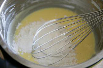 5、轻乳酪杯子蛋糕,在奶酪糊中加入提前过筛的低筋面粉和玉米淀粉，用打蛋器拌匀至无面粉颗粒后，把奶酪糊放进冰箱冷藏15分钟。