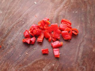 3、猪头肉拌黄瓜,把红辣椒用刀切成小块。