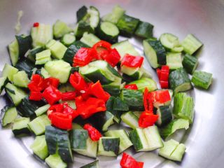 6、猪头肉拌黄瓜,先把切好的黄瓜和红辣椒放入盆中。