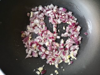 8、西班牙海鲜饭,锅中适量橄榄油烧热后下洋葱和蒜末炒香。