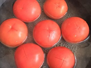 1、红烧牛肉面,蕃茄划十字刀放入沸水中煮两分钟，底部煮一分钟后翻转顶部再煮一分钟。