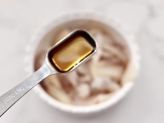 4、蚝香蒜薹鱿鱼小炒,把改好刀的鱿鱼倒入料酒腌制10分钟。