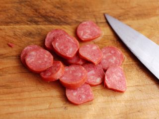 3、对虾红肠时蔬泡面,把红肠用刀切成薄片。